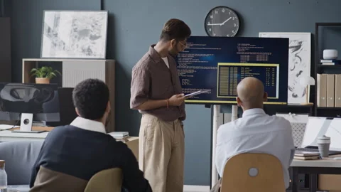 Indian Software Engineer Presenting Code to Multiethnic IT Team in Office Stock Footage 337484776