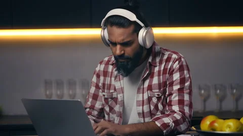 Indian software tester in headset using laptop, frustrated with program failure Stock Footage 316836254