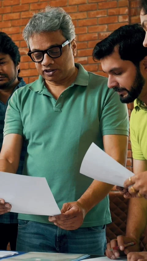 Indian startup team discussing project strategy with a laptop and documents Stock Footage 342507904