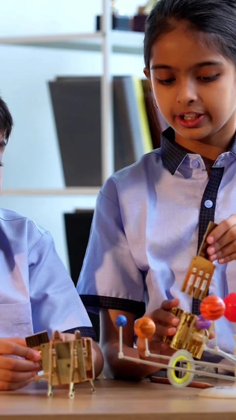 Indian students in uniform explore satellite model in classroom lesson on space Stock Footage 342844178