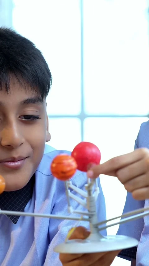 Indian students in uniform study planets using 3D solar system model, observe Stock Footage 342844155