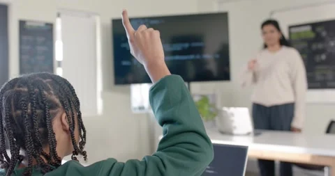 Indian teacher explaining code on monitor, responding to youth student raising Stock Footage 341029010