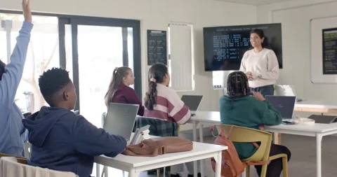 Indian teacher with teens in lab asking question while teens with laptops Stock Footage 341079723