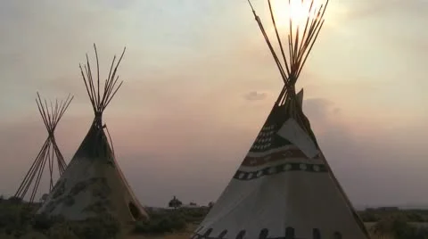 Indian teepees stand in a native american encampment at sunset. Stock Footage