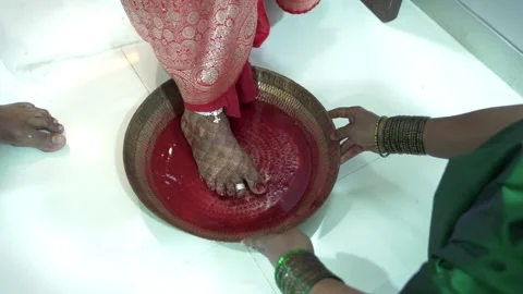 "Indian Wedding Ritual of Bride Placing Foot in Red Water" Stock Footage 325046476