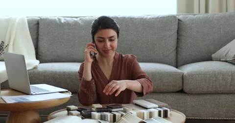 Indian woman discuss on phone color of tiles with customer Stock Footage