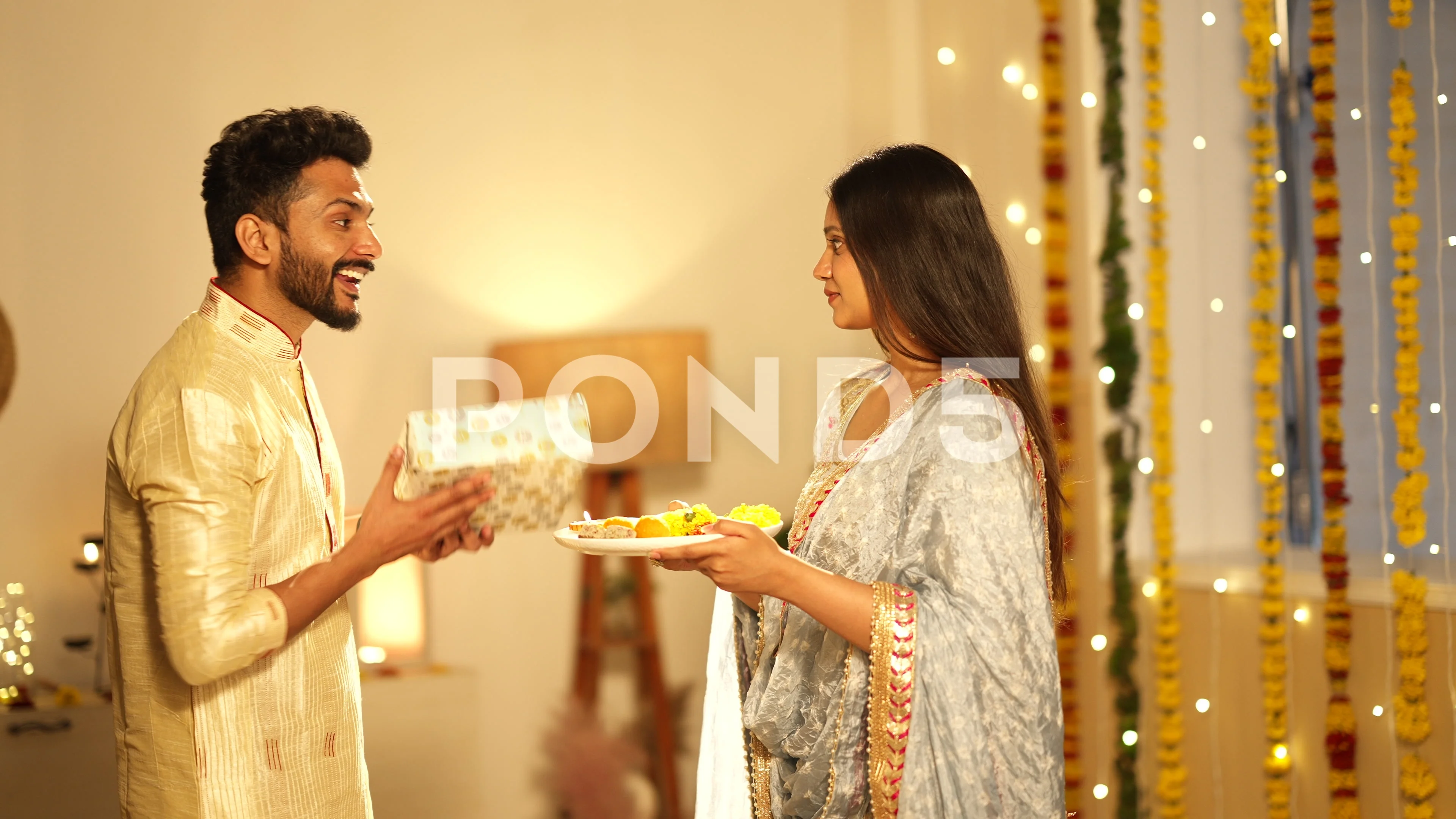 Indian woman performing aarti for her husband and he gave gift.