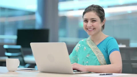 Indian Woman Smiling at Camera while using Laptop Stock Footage 152522070