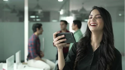 Indian woman standing while using smart phone watching funny videos. Vídeos de archivo 170129031