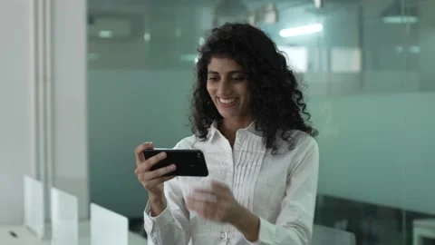 Indian woman standing while using smart phone watching funny videos. Видео 170417300