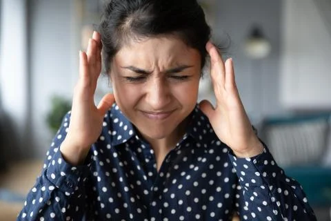 Indian woman suffering from strong head ache or loud noises. Stock Photos