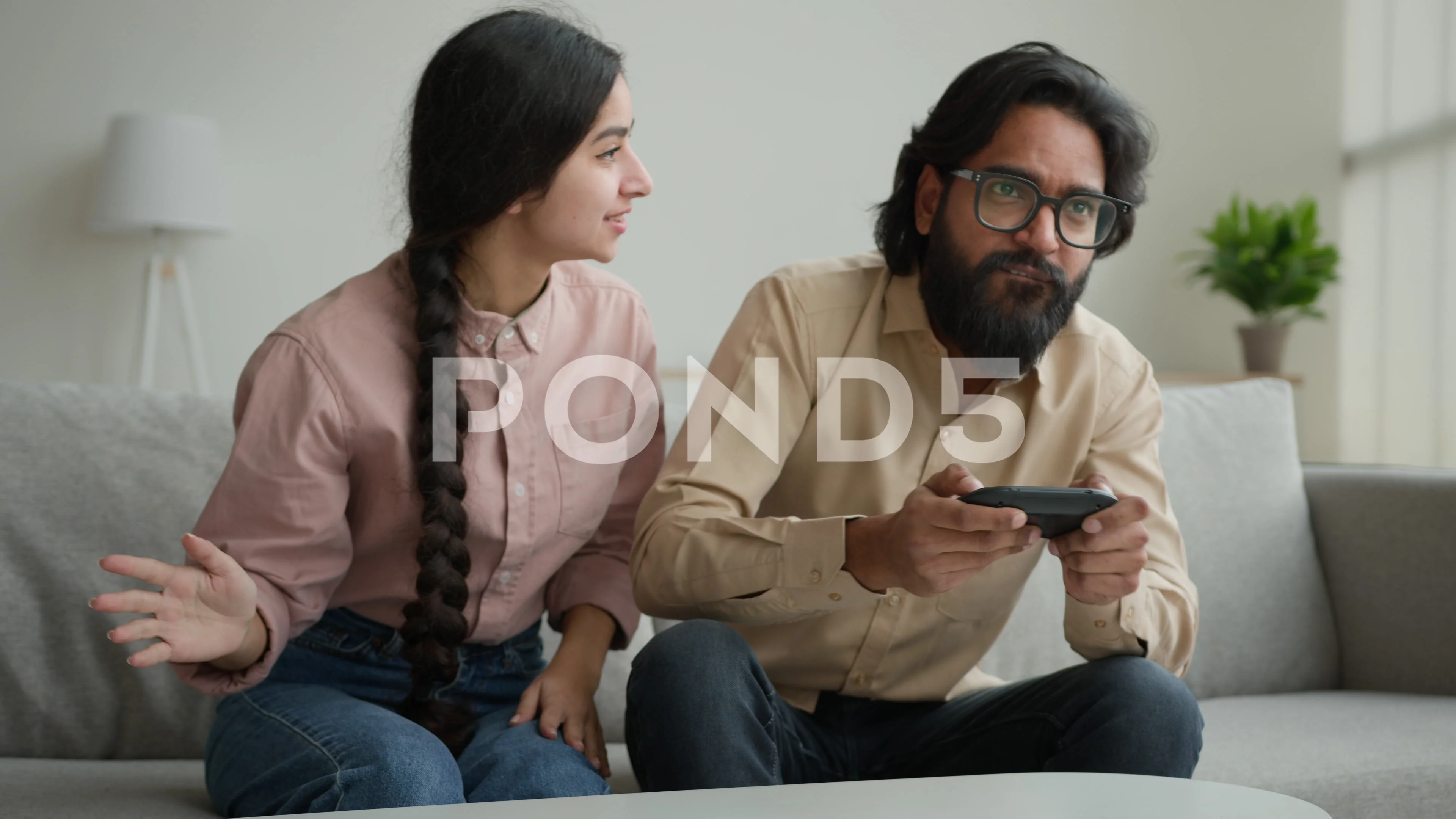 Indian woman wife distract husband from playing virtual game focused Arabian