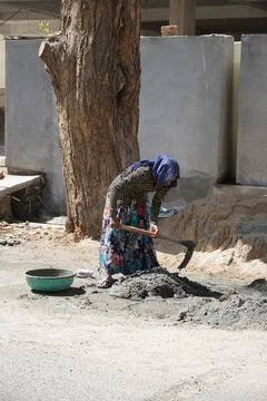 An indian woman worker is working her heavy labor day job at the construction 스톡 사진
