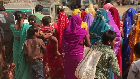 Indian women with children walking at the road with their backs to us Stock Footage