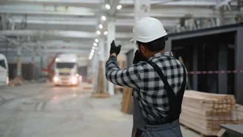 Indian worker directing truck for modular home transportation Video stock 301821867