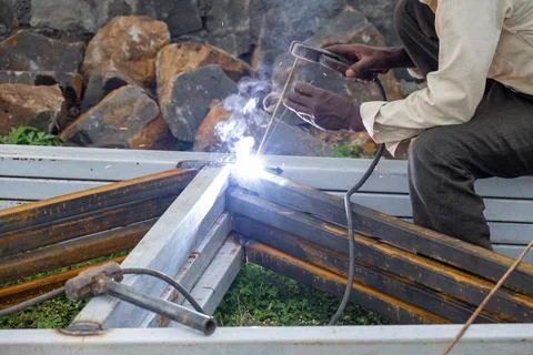 Indian worker doing welding. Close-up Metal worker welding iron in a workshop Stock Photos