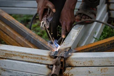 Indian worker doing welding. Close-up Metal worker welding iron in a workshop Stock Photos