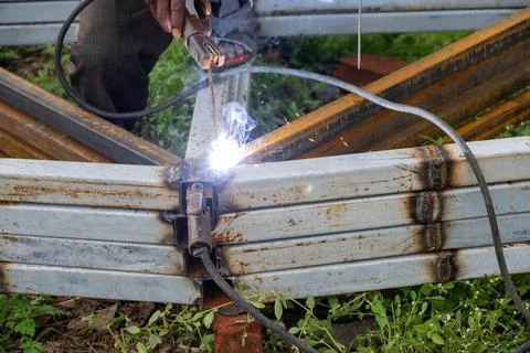 Indian worker doing welding. Close-up Metal worker welding iron in a workshop Stock Photos