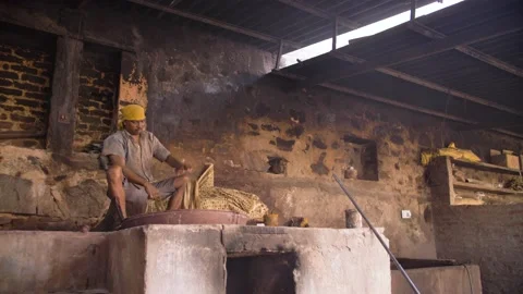 Indian worker dyeing block printed textiles in a pot with organic pigments. Stock Footage 151904565