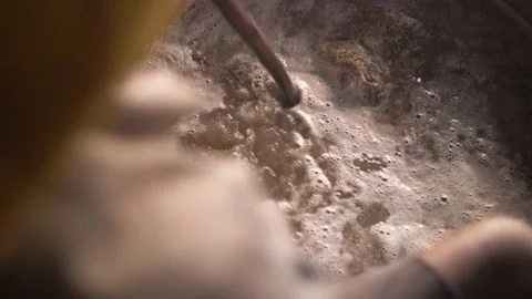 Indian worker dyeing block printed textiles in a pot with organic pigments. Stock Footage 151904642