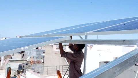 Indian worker installing solar panels on roof of house. Maintenance of phot.. Stock Footage 270753037