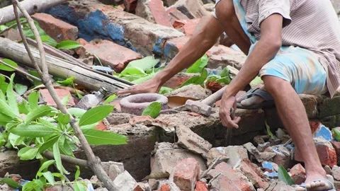 A Indian worker remove old plaster from brick and restore it for reuse purpos 스톡 동영상 137890094