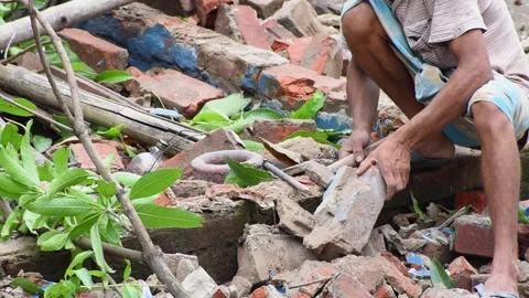 A Indian worker remove old plaster from brick and restore it for reuse purpos Vídeo Stock 137890121