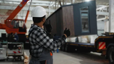 Indian worker supervising modular home loading with crane Stock Footage 301822823