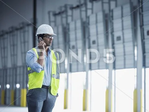 Indian Worker Talking On Cell Phone At Loading Dock