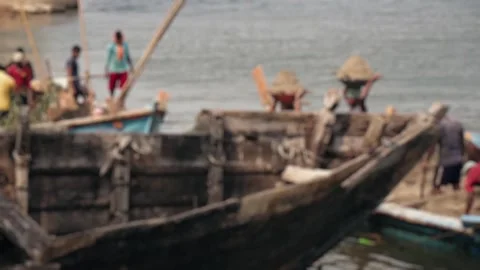 Indian workers unloading sand from a traditional boat Stock Footage 345900274