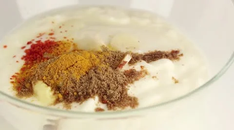 Indian yogurt marinade being made: sesame oil and spices being added to yogurt 스톡 동영상 24656980