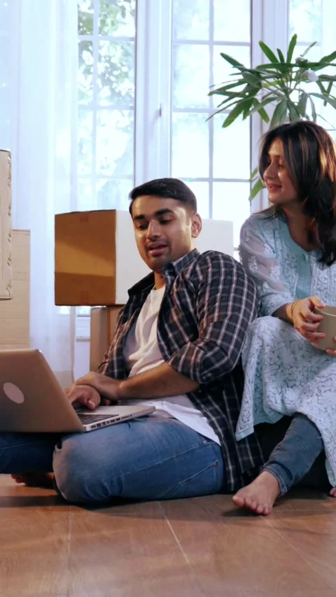 Indian Young couple designing layout for new home, surrounded boxes Stock Footage 343405815