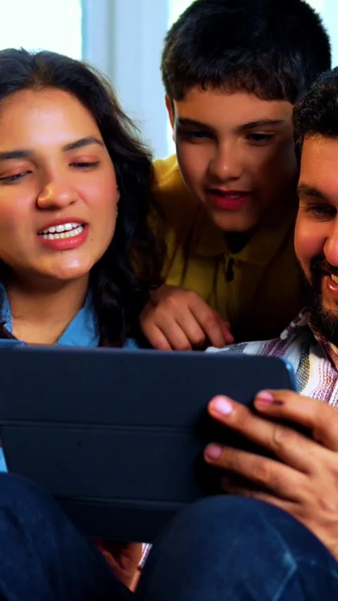 Indian young family using tablet computer at home browsing content together Video stock 342804030