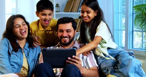 Indian young family using tablet computer at home browsing content together 스톡 동영상 342804949