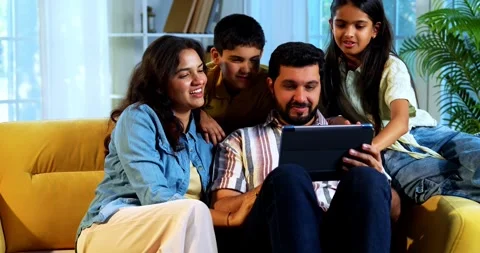 Indian young family using tablet computer at home browsing content together Stock Footage 342804956