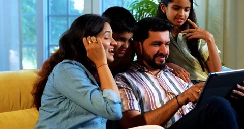 Indian young family using tablet computer at home browsing content together Stock Footage 342804966