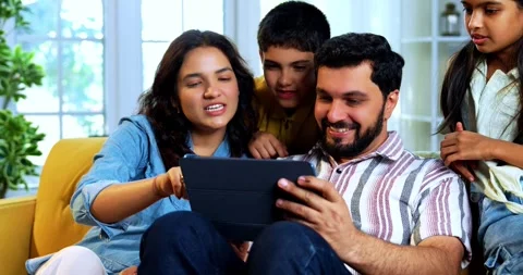 Indian young family using tablet computer at home browsing content together 스톡 동영상 342804968