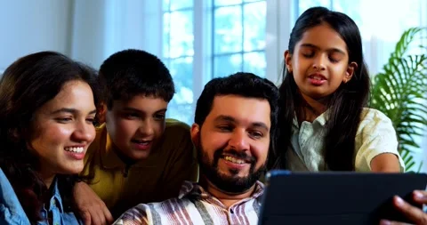 Indian young family using tablet computer at home browsing content together Stock Footage 342804969