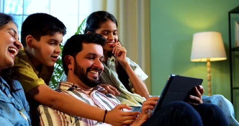 Indian young family using tablet computer at home browsing content together 스톡 동영상 342804973