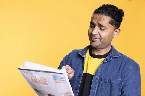 Indian young guy browsing though financial audit report paperwork Stock Photos