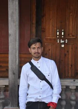 A Indian young guy looking at camera while stranding in temple Stock Photos