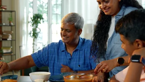 Indian young parents and two small kids eating together at home Video stock 343367628