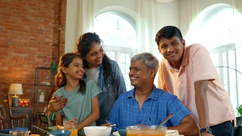 Indian young parents and two small kids eating together at home Stockbeeldmateriaal 343367767