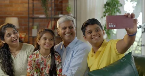 Indian young parents and two small kids spending quality time together indoors Stock Footage 343369040