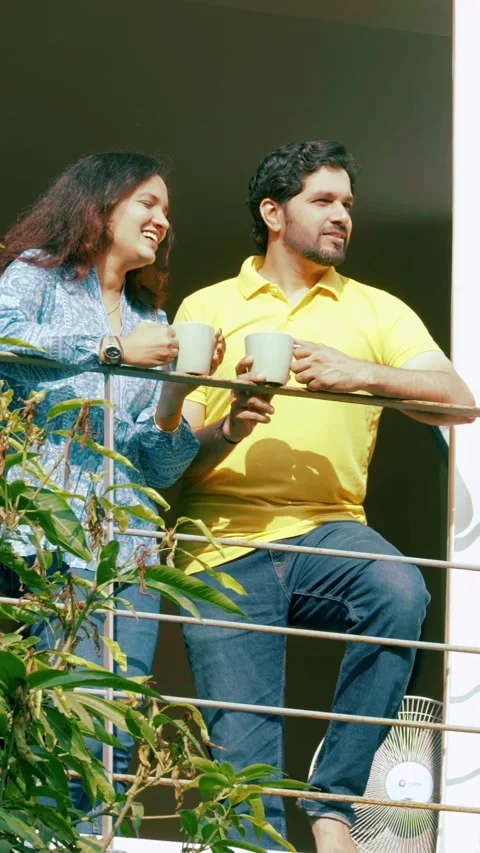 Indian young smart couple spending quality time standing at balcony chatting Stock-Footage 343415508