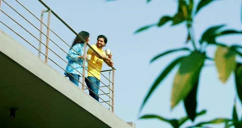 Indian young smart couple spending quality time standing at balcony chatting Video stock 343418565