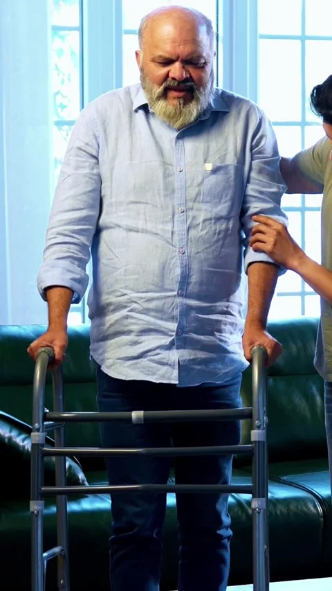Indian young Son Helping aged Father Stand And Walk With Walker Support At Home Stockbeeldmateriaal 342757634