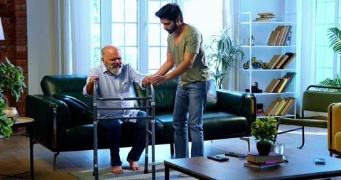 Indian young Son Helping aged Father Stand And Walk With Walker Support At Home Stockbeeldmateriaal 342778619