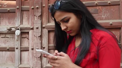 Indian young woman using a cell phone mobile device in Rajasthan, India Stock Footage