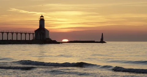 Indiana - Sun Setting Behind Lighthouse Over Lake Michigan - 4K Slow Motion Stock Footage 111928687
